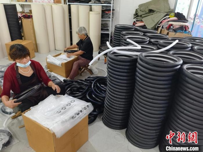 圖為村民在汽車飾品企業(yè)生產(chǎn)車間中工作。　呂子豪 攝