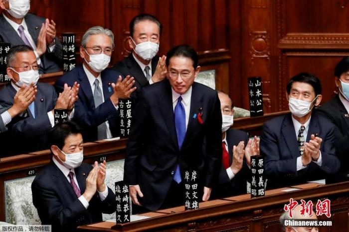 當?shù)貢r間10月4日，日本自民黨總裁岸田文雄經(jīng)過眾院全體會議的首相指名選舉成為第100任首相。圖為岸田文雄（中）起身致謝。