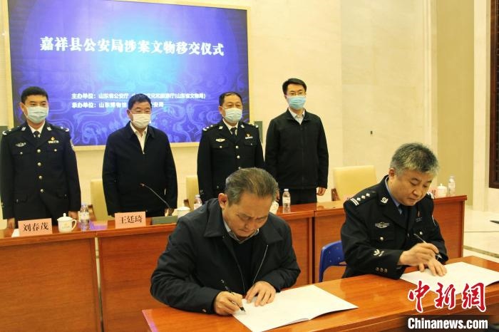 山東博物館館長鄭同修和嘉祥縣人民政府副縣長、公安局局長趙健簽署移交協(xié)議。　趙曉 攝