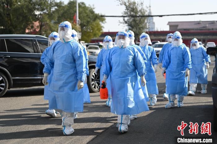 圖為醫(yī)務(wù)人員在封閉小區(qū)做防控工作?！⑽娜A 攝
