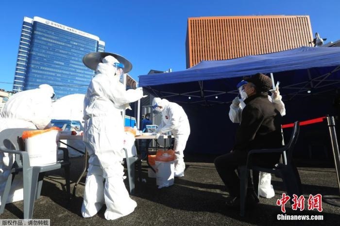 資料圖：韓國(guó)首爾，醫(yī)務(wù)人員對(duì)市民進(jìn)行新冠病毒檢測(cè)。