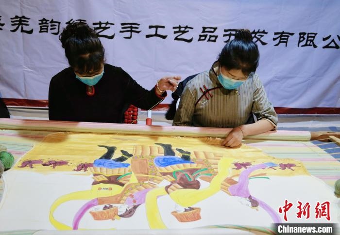 圖為皮繡藝人在市集上“秀”指尖技藝?！●R銘言 攝