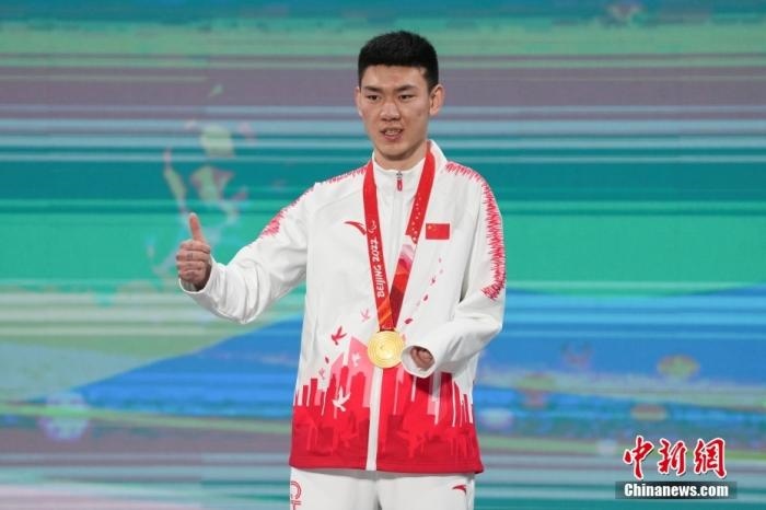 3月6日，梁景怡在延慶頒獎(jiǎng)廣場(chǎng)領(lǐng)獎(jiǎng)臺(tái)上豎起大拇指。當(dāng)日，在國(guó)家高山滑雪中心舉行的北京2022年冬殘奧會(huì)殘奧高山滑雪男子超級(jí)大回轉(zhuǎn)—站姿決賽中，中國(guó)選手梁景怡奪得冠軍。 <a target='_blank' href='/'>中新社</a>記者 楊華峰 攝