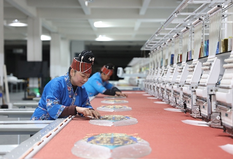 2023年2月13日，貴州省黔東南苗族侗族自治州施秉縣工業(yè)園區(qū)，工人在機(jī)繡車間作業(yè)。