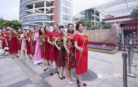6月7日一早，廈門雙十中學(xué)考生家長(zhǎng)們身穿旗袍，手拿向日葵在考場(chǎng)外為孩子加油打氣，寓意“旗開得勝，一舉奪魁”。人民網(wǎng)記者 陳博攝