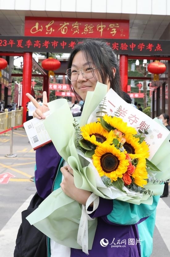 6月7日高考首日，山東67萬考生走進(jìn)考場(chǎng)，拼搏逐夢(mèng)。在山東省實(shí)驗(yàn)中學(xué)考點(diǎn)，考生進(jìn)考場(chǎng)前手捧向日葵花拍照留念，寓意“一舉奪魁”。人民網(wǎng)記者 劉祺攝