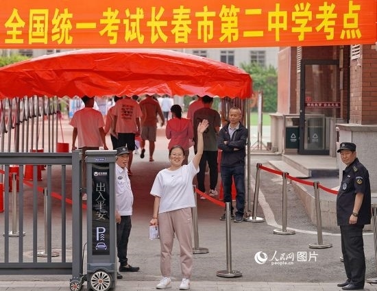 6月7日，在長(zhǎng)春市第二中學(xué)考點(diǎn)，一名考生信心滿滿進(jìn)入考場(chǎng)，并與家長(zhǎng)揮手致意。人民網(wǎng)記者 李洋攝