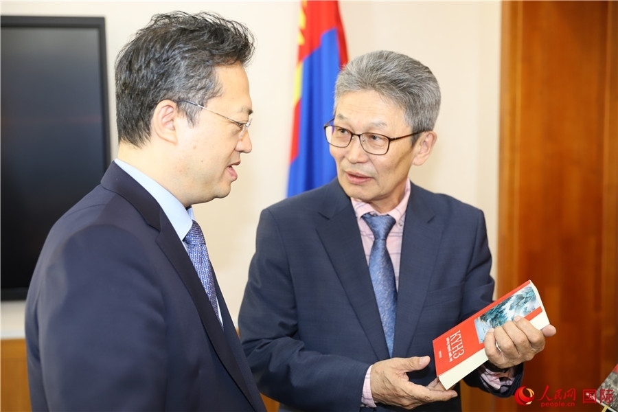 其米德策耶（右一）向李峙介紹翻譯成果。人民網(wǎng)記者 霍文攝