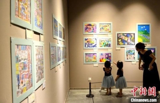 圖為家長(zhǎng)帶著孩子參觀展覽。呂明 攝