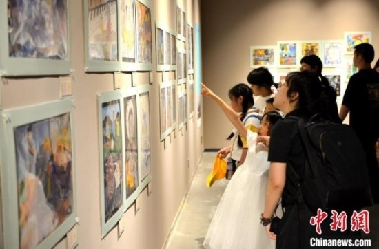 圖為家長(zhǎng)帶著孩子參觀展覽。呂明 攝