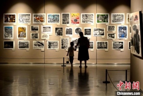 圖為家長(zhǎng)帶著孩子參觀展覽。呂明 攝