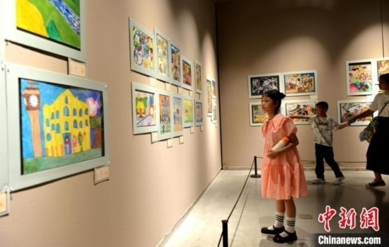 圖為家長(zhǎng)帶著孩子參觀展覽。呂明 攝