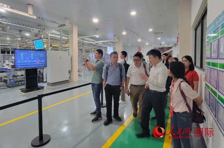 廣汽埃安工作人員向外媒記者進(jìn)行介紹。人民網(wǎng) 寧玉瑛攝