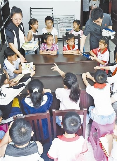  圖④：法院干警為留守兒童發(fā)放暑假讀物。