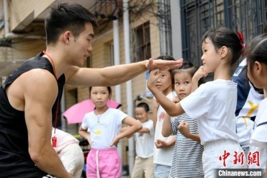 圖為大學(xué)生志愿者在組織孩子們參加體育健身活動(dòng)。廖光福 攝