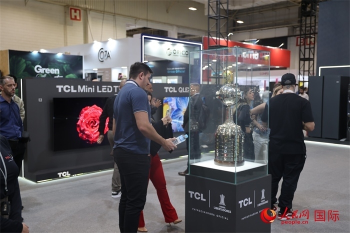 參觀者在TCL展臺(tái)前觀看南美解放者杯獎(jiǎng)杯，據(jù)介紹，TCL是南美解放者杯（2023—2026賽季）全球官方合作伙伴。（人民網(wǎng)記者 時(shí)元皓攝）