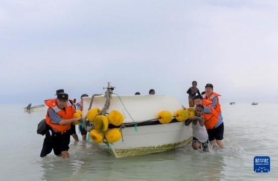 7月21日，中國海軍“和平方舟”號醫(yī)院船醫(yī)護人員涉水登島，前往基里巴斯一診療點。新華社記者 黎云 攝