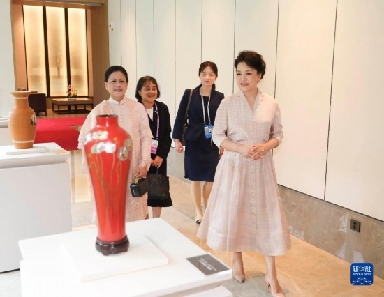 7月27日下午，國(guó)家主席習(xí)近平夫人彭麗媛在四川成都會(huì)見陪同印度尼西亞總統(tǒng)佐科來(lái)華出席第31屆世界大學(xué)生夏季運(yùn)動(dòng)會(huì)開幕式并訪華的總統(tǒng)夫人伊莉亞娜。這是彭麗媛和伊莉亞娜欣賞成都特色非遺工藝品。新華社記者 丁林 攝