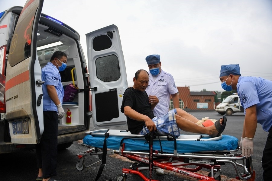 8月1日，在北京市門頭溝區(qū)妙峰山鎮(zhèn)妙峰山民族學(xué)校臨時安置點，北京急救中心工作人員在轉(zhuǎn)運一名受傷村民。新華社記者 鞠煥宗 攝