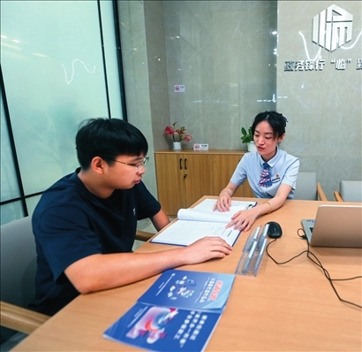 在杭州市臨安區(qū)政務(wù)服務(wù)中心的“為企服務(wù)中心”，黨員志愿者（右）解答企業(yè)主的疑問（2023年7月7日攝）。徐昱攝/本刊