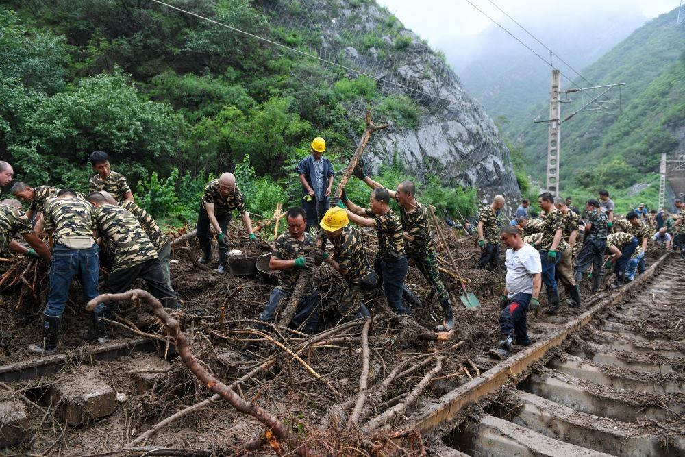 8月1日，在北京市門頭溝區(qū)水峪嘴村附近一段被阻斷的鐵路線上，中鐵六局工作人員在清理軌道上的雜物，全力恢復(fù)交通。新華社記者 鞠煥宗 攝