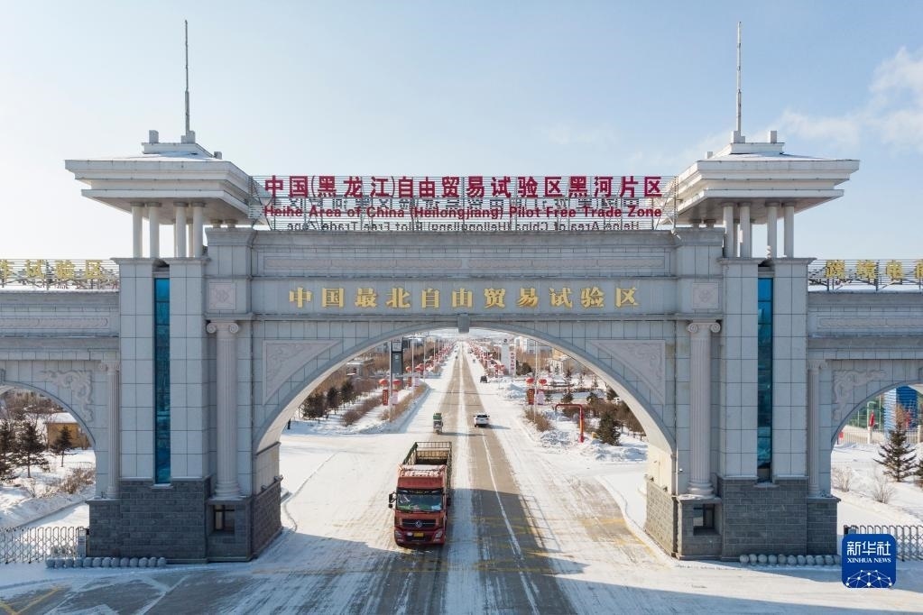 2月11日，車輛駛出中國(guó)（黑龍江）自由貿(mào)易試驗(yàn)區(qū)黑河片區(qū)大門（無(wú)人機(jī)照片）。新華社記者 謝劍飛 攝