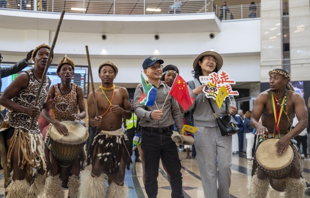 在南非約翰內(nèi)斯堡坦博國際機(jī)場，南非舞蹈演員歡迎中國試點(diǎn)恢復(fù)出境團(tuán)隊(duì)旅游后首批抵達(dá)南非的中國游客（2023年3月29日攝）。