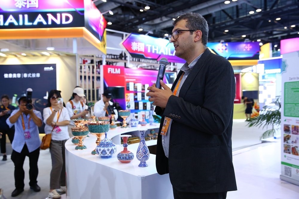 9月1日，參展商在國家會議中心向媒體記者介紹展臺信息。新華社記者 孫瑋彤 攝