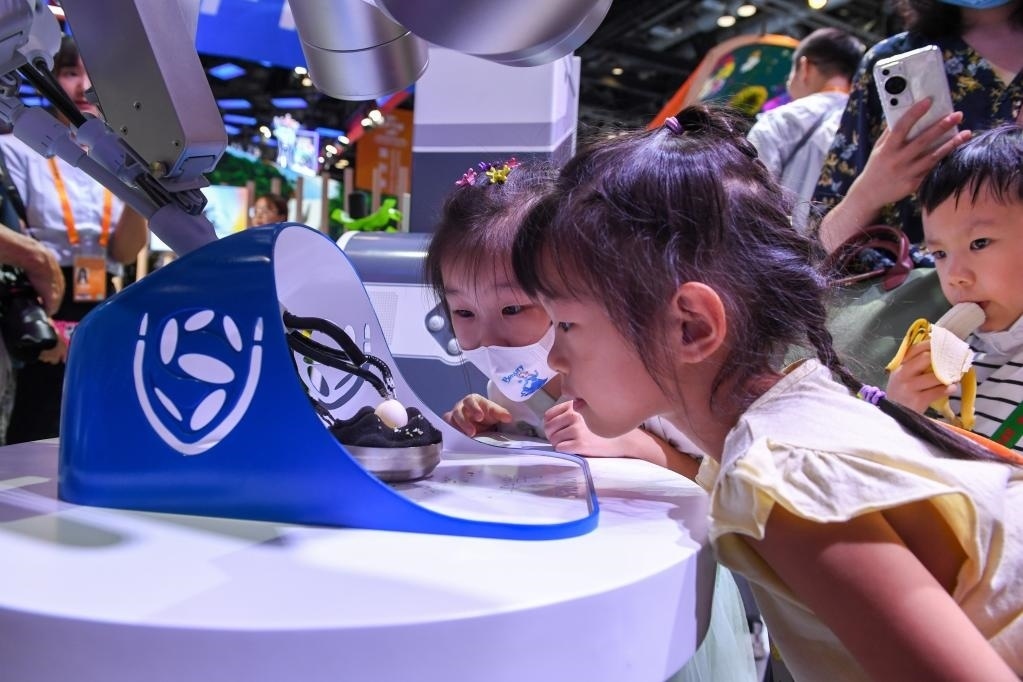 9月3日，幾名小朋友在國(guó)家會(huì)議中心觀看單孔腔鏡手術(shù)機(jī)器人展示。新華社記者 鞠煥宗 攝