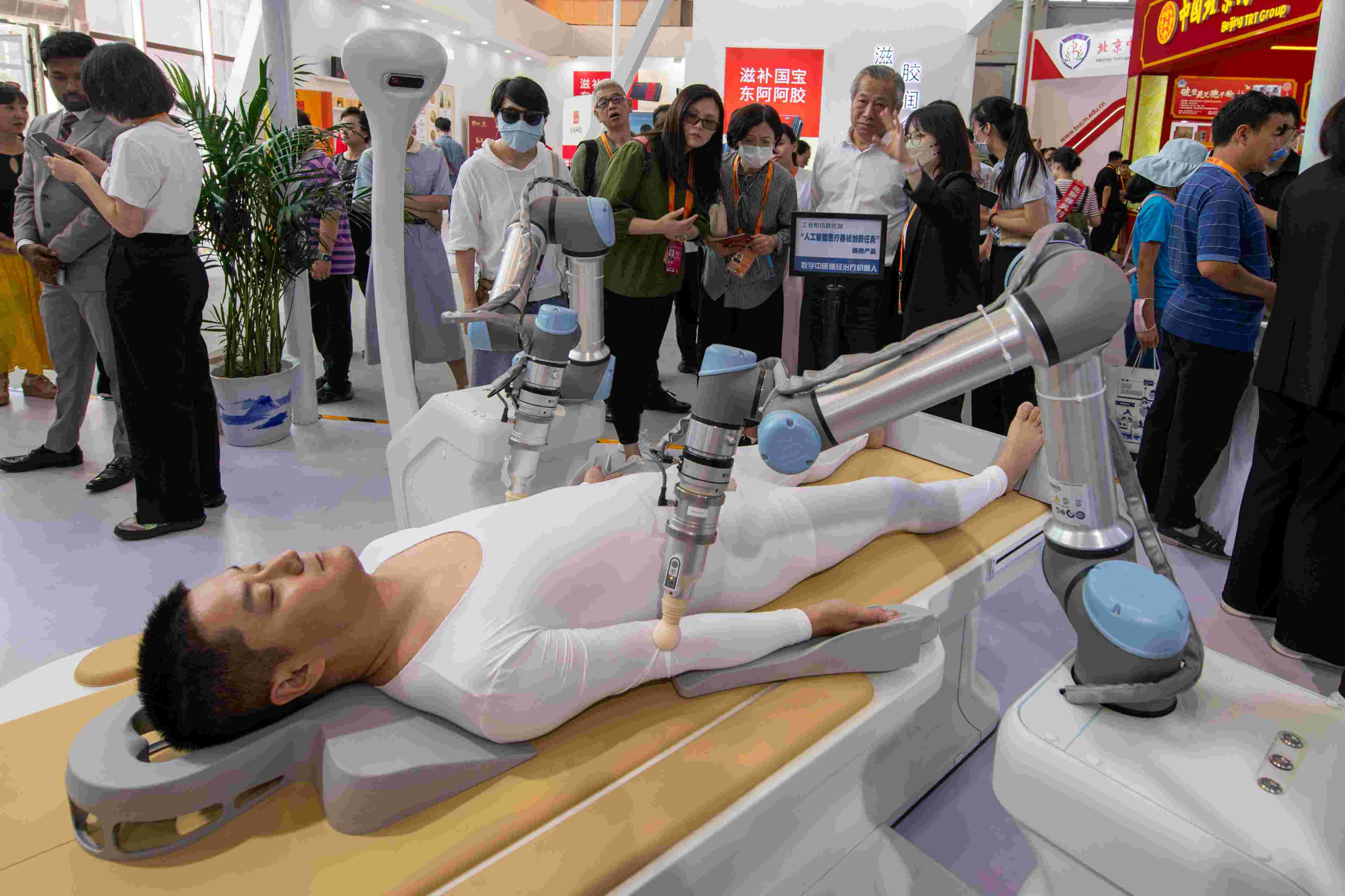 在位于首鋼園的健康衛(wèi)生服務(wù)展區(qū)，觀眾正在參觀數(shù)字中醫(yī)循經(jīng)治療機(jī)器人。人民網(wǎng)記者 翁奇羽攝