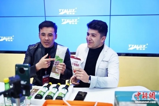 2023年3月，甘肅省慶陽(yáng)市環(huán)縣電商創(chuàng)業(yè)孵化基地內(nèi)，來(lái)自蘭州文理學(xué)院的塔吉克斯坦留學(xué)生正在協(xié)助主播直播帶貨當(dāng)?shù)剞r(nóng)特產(chǎn)品。李亞龍 攝