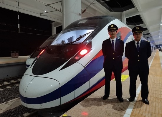 劉銀能（右一）與中國師父鄔俊鴻在動(dòng)車組前合影。受訪者供圖