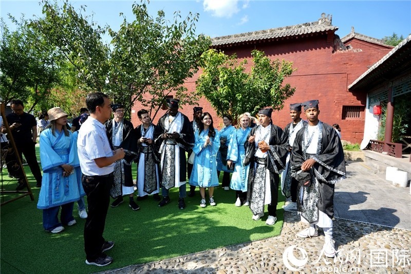 圖為選手們聽(tīng)導(dǎo)游講解。人民網(wǎng) 盧鵬宇攝