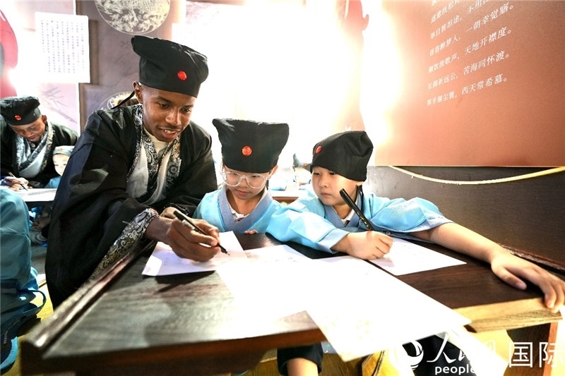 圖為選手與同學(xué)們一起寫書法。人民網(wǎng) 盧鵬宇攝