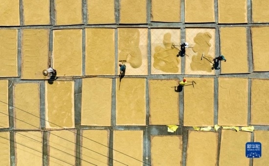 9月16日，在湖南省懷化市通道侗族自治縣萬(wàn)佛山鎮(zhèn)溪上村，村民在晾曬稻谷（無(wú)人機(jī)照片）。