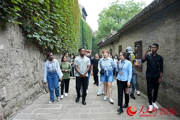 選手們認真聆聽導(dǎo)游講解。人民網(wǎng) 盧鵬宇攝