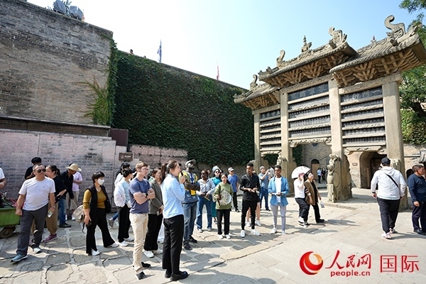 選手們認真聆聽導(dǎo)游講解。人民網(wǎng) 盧鵬宇攝