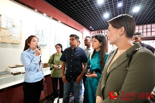 選手們認真聆聽導(dǎo)游講解。人民網(wǎng) 盧鵬宇攝