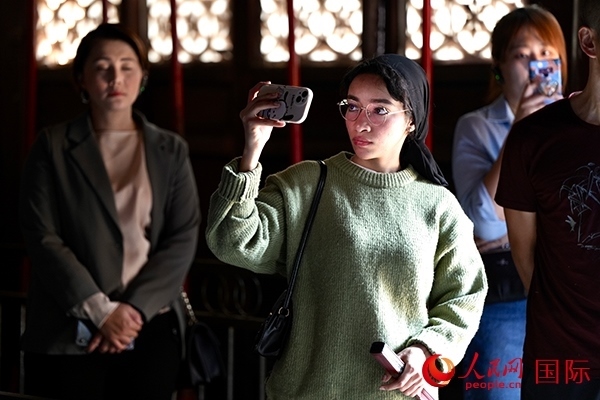 選手顏青（蘇丹）用手機記錄所見所感。人民網(wǎng) 盧鵬宇攝