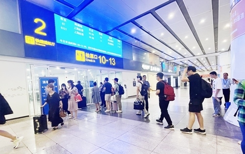 在快速進(jìn)站廳前排隊等待檢票的旅客。人民網(wǎng)記者 喬雪峰攝