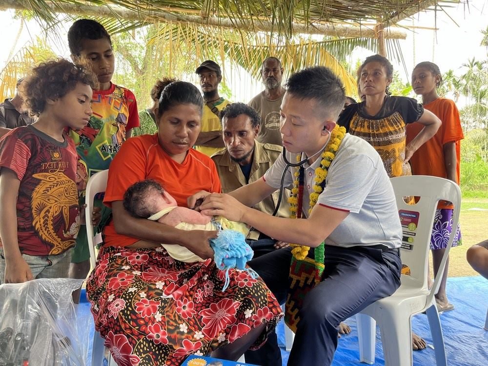 2023年8月5日，在巴布亞新幾內(nèi)亞中央省的一個(gè)村莊里，第12批援巴新中國醫(yī)療隊(duì)副隊(duì)長、新生兒科副主任醫(yī)師劉振球?yàn)楫?dāng)?shù)貗雰郝犜\檢查。新華社發(fā)（第12批援巴新中國醫(yī)療隊(duì)供圖）