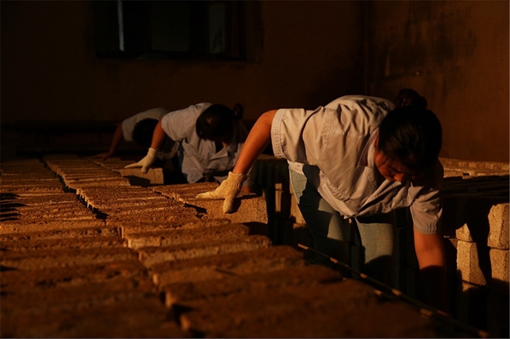 匠人師傅正在翻動曲胚。張?zhí)炝z