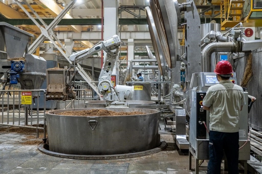 907車間里，機(jī)械臂正在撒料裝甑。嚴(yán)磊攝