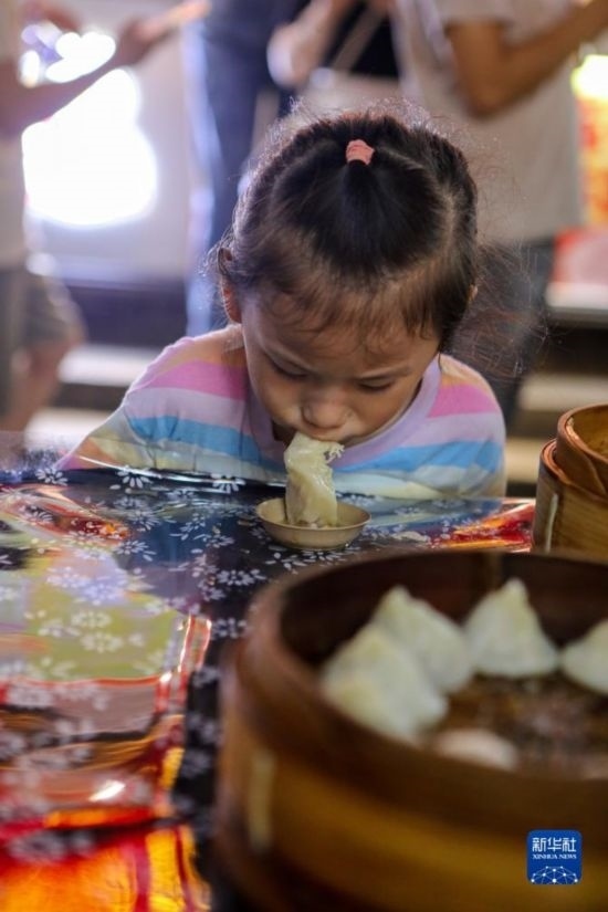 9月27日，小朋友在南翔小籠長街宴上品嘗南翔小籠。