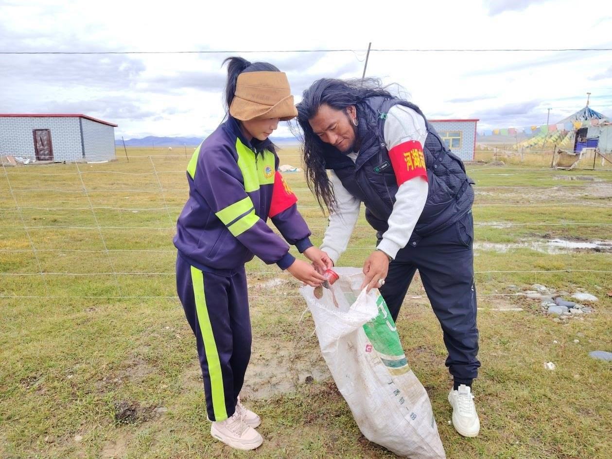 玉樹州稱多縣珍秦鎮(zhèn)河湖志愿者才培和他女兒更求拉毛在清掃垃圾。受訪者供圖