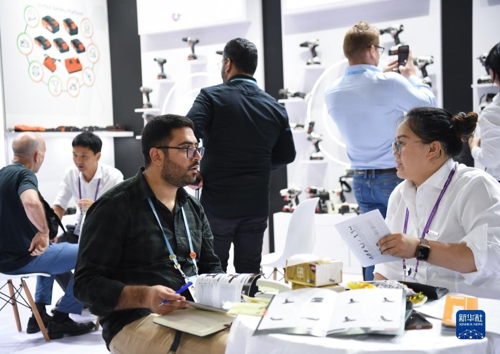 10月15日，在一家電動(dòng)工具展臺(tái)，外國(guó)采購(gòu)商在洽談業(yè)務(wù)。新華社記者 鄧華 攝