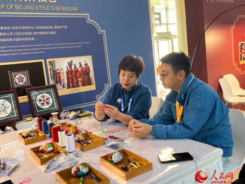 記者在新聞中心非遺傳承人展區(qū)進(jìn)行體驗(yàn)。人民網(wǎng)記者 杜燕飛攝