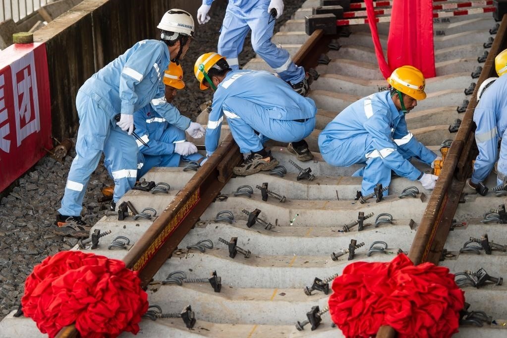 3月31日，在印度尼西亞雅加達雅萬高鐵哈利姆車站，工人鋪設(shè)雅萬高鐵全線最后一根鋼軌。