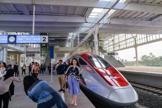  10月17日，在印度尼西亞萬隆德卡魯爾站，乘客在站臺(tái)上和雅萬高鐵高速動(dòng)車組列車合影。新華社記者 徐欽 攝