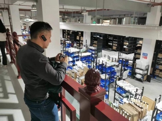 2023“一帶一路”媒體合作論壇聯(lián)合采訪團團員在仁和醫(yī)藥物流園拍攝記錄轉運流程。（本報記者 黃超攝）